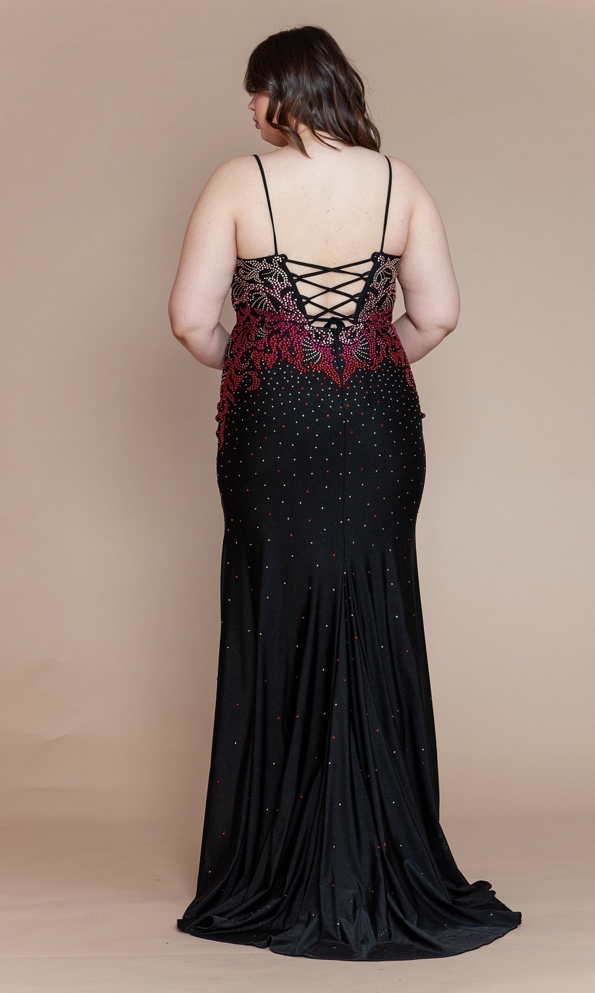 A woman models the Ombre-Beaded Plus-Size Long Prom Dress W1138, showcasing its lace-up back and red embellishments as she stands with her back to the camera against a beige background.